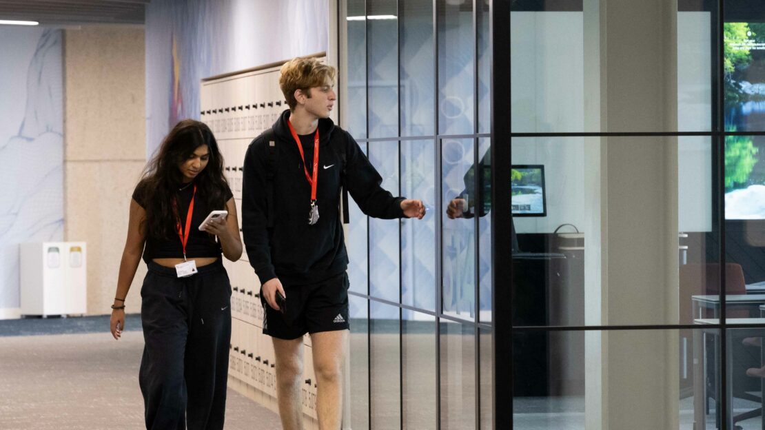 Two students walking inside Northeastern University London's campus building