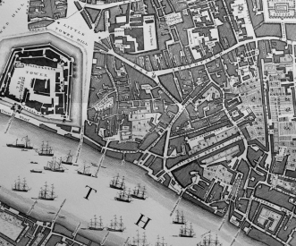 A black and white historical map showing a detailed layout of a coastal city with streets, buildings, and a fortified area. Numerous sailing ships are illustrated on the waterway adjacent to the city.